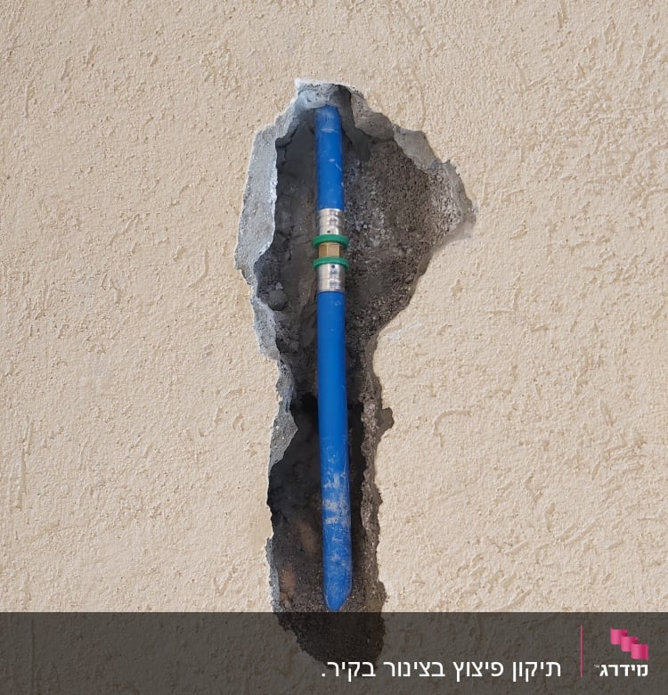 צינור כחול בקיר שבור עם חיבור מתכת